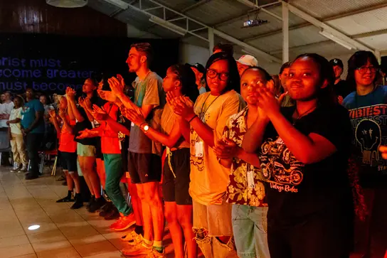 Campers clapping and cheering in a hall