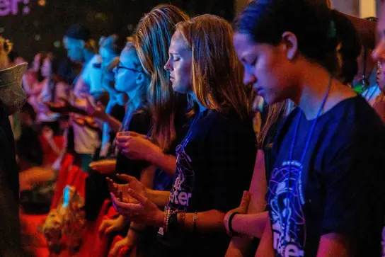 Two campers looking down during a worship time