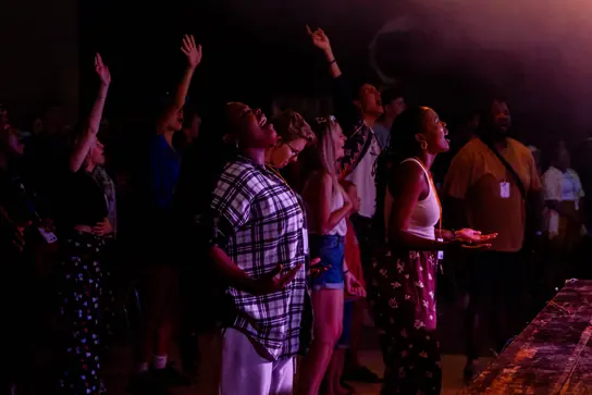 Campers with raised hands during worship