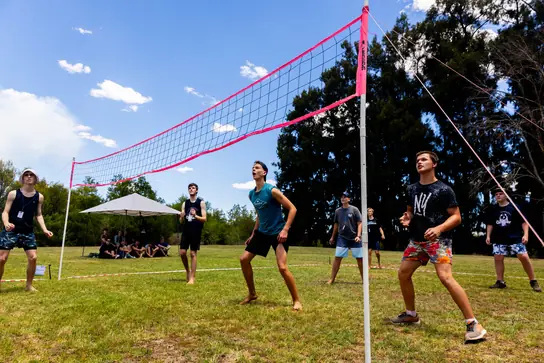 Campers playing volleyball on the grass